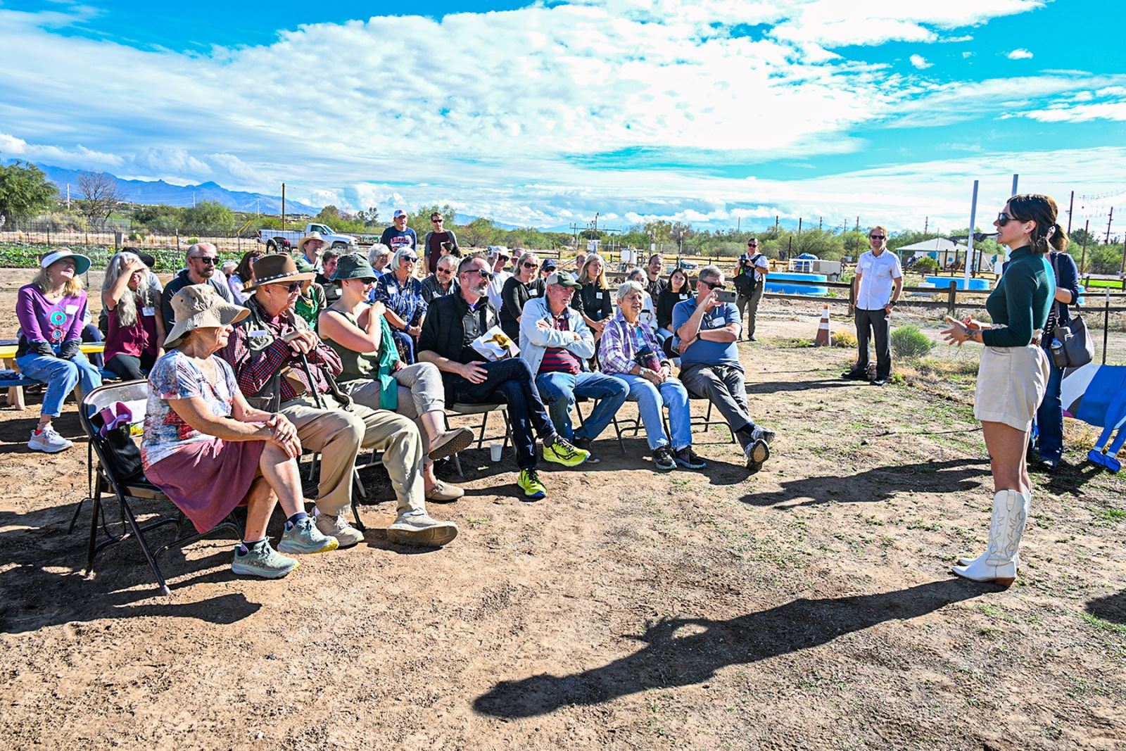 A group of people listens to an award presentation for John Brooks at ߲о Village Farm.